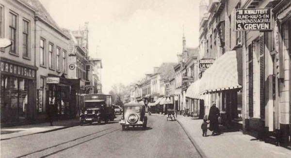 De Grutstraat met rechts achter het zonnescherm het uithangbord van L.H. Wink te zien