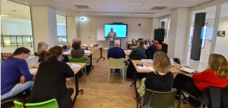 Foto van een klas die een schrijfcursus volgt