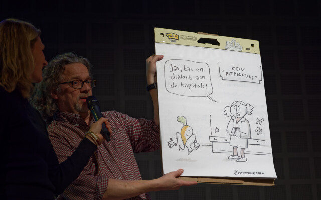 Foto impressie van het streektaalsymposium Plat voor Pottwottels ''dialect aan de kapstok''. Op dexe foto is te zien: Cartoonis Herman Roozen met een getekende strip Foto impressie van het streektaalsymposium Plat voor Pottwottels ''dialect aan de kapstok''. Op dexe foto is te zien: Cartoonis Herman Roozen met een getekende strip
